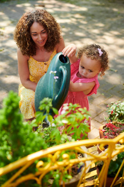 arroser les plantes - mother family vertical flower photos et images de collection