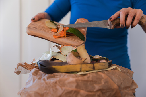 Close-up of woman making a pile of organic waste for composting