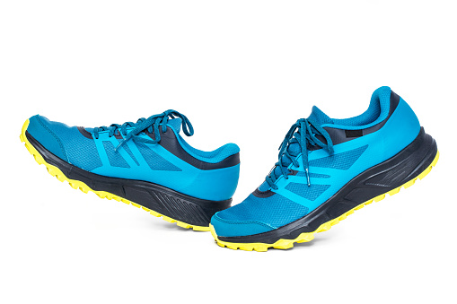 Pair of trail-running sneakers isolated on white background.