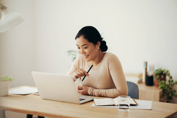 istock Cheerful Business Woman Working from Home on Laptop Computer 1350926550
