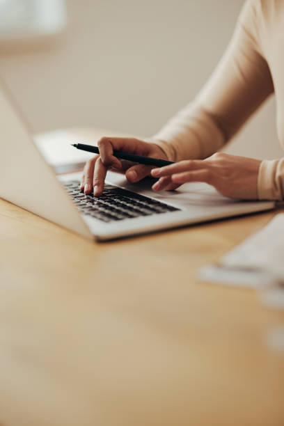 nahaufnahme von frauenhänden, die einen geschäftsbericht auf einem laptop-computer eingeben - computer keyboard computer human hand business stock-fotos und bilder