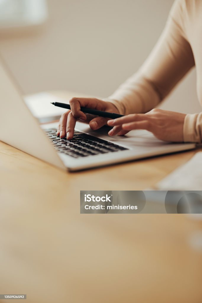 Close Up of Woman Hands Typing Business Report on a Laptop Computer An anonymous Asian businesswoman working on her laptop computer while sitting at desk in her office Laptop Stock Photo