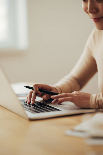 close up of woman hands typing business report on a laptop computer - contemporary laptop human hand computer keyboard imagens e fotografias de stock