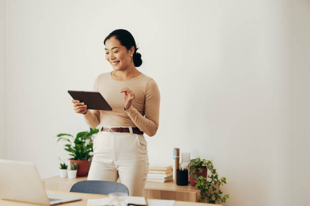istock Cheerful Business Woman Using Digital Tablet at Home 1350926649