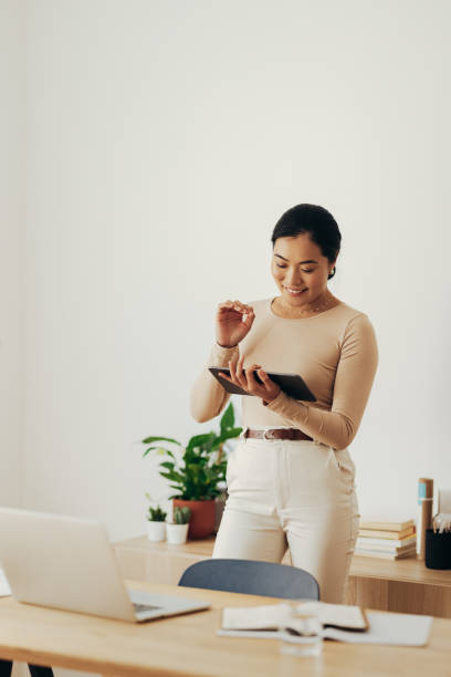 istock Cheerful Business Woman Using Digital Tablet at Home 1350926658