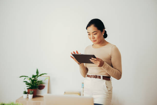 istock Smiling Business Woman Using Digital Tablet at Home 1350926677