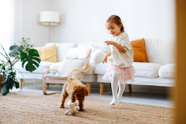 istock Little girl playing with dog 1350928628