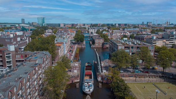 istock Aerial drone view of a ship passing elevating road bridge in amsterdam canal. Ship under open bridge over the canal. 1350930226