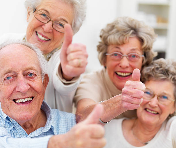 adulti senior felice mostrando pollice in alto - adult group of people ecstatic excitement foto e immagini stock