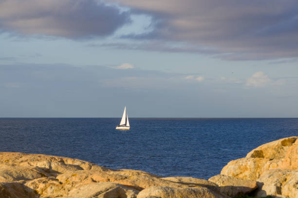 istock Sailboat sailing at sunset 1350934380