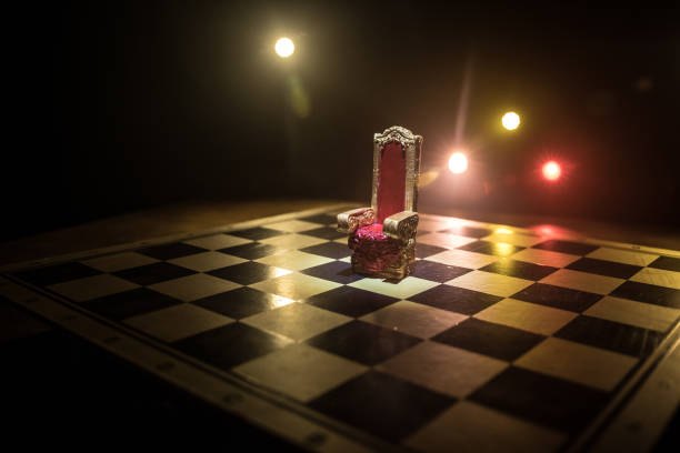 istock Red royal chair miniature on wooden table. Medieval Throne on chessboard. Chess board game concept of business ideas and competition and strategy ideas concept. 1350936178