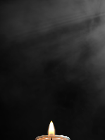 Burning candle with black background