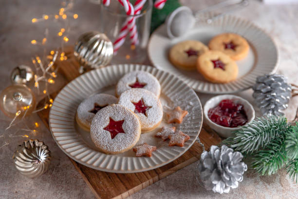 biscotti di natale linzer ripieni di marmellata di lamponi su sfondo di cemento - marmalade baked biscuit brown foto e immagini stock