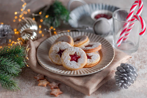 biscotti di natale linzer ripieni di marmellata di lamponi su sfondo di cemento - marmalade baked biscuit brown foto e immagini stock