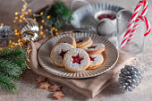 Linzer Christmas cookies filled with raspberry jam on concrete background