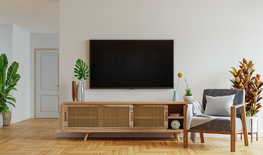 Maqueta de televisión montada en la pared con gabinete y sillón sobre fondo de pared blanco. photo