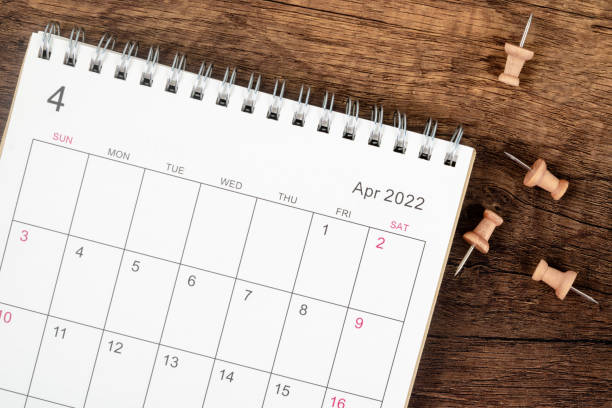 トップビューカレンダーデスク2022 4月、木製テーブルの背景にプッシュピン付きの計画と締め切りの概念。 - 四月 ストックフォトと画像