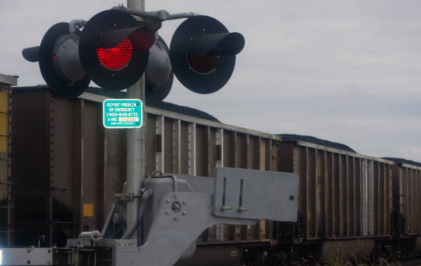 istock Train track warning lights with a train in the background. 1350955301