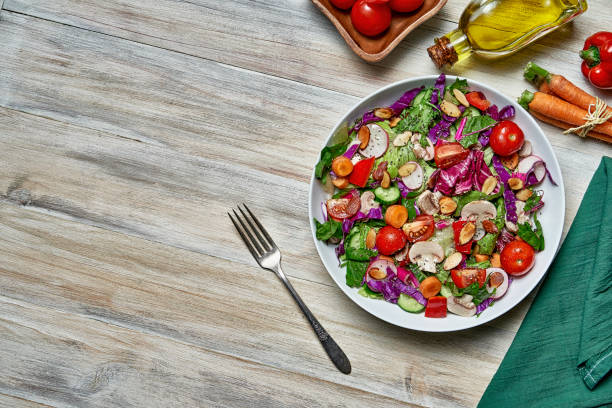 istock Diet concepts. Spring salad shot from above on rustic wood table with copy space 1350956062