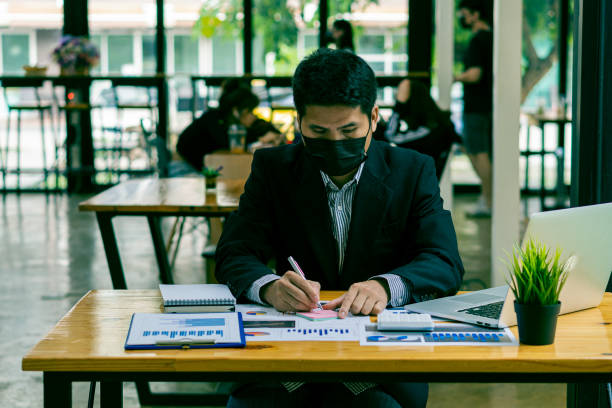 istock young businessman looking at market research report Analyze statistical data in charts. Develop a growth strategy working on a laptop alone in his office 1350957057