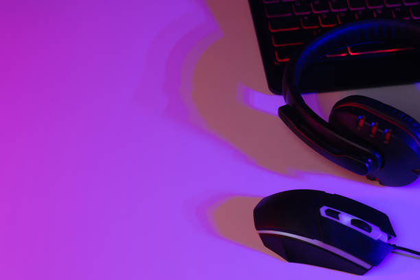 istock Accessory gaming keyboard joystick mouse headphone with blank space. Gadget for gamer playing video game online in the neon light darkroom. 1350960521