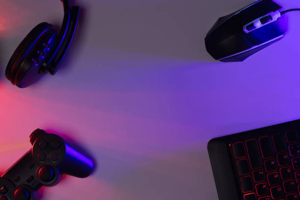 istock Accessory gaming keyboard joystick mouse headphone with blank space. Gadget for gamer playing video game online in the neon light darkroom. 1350960524