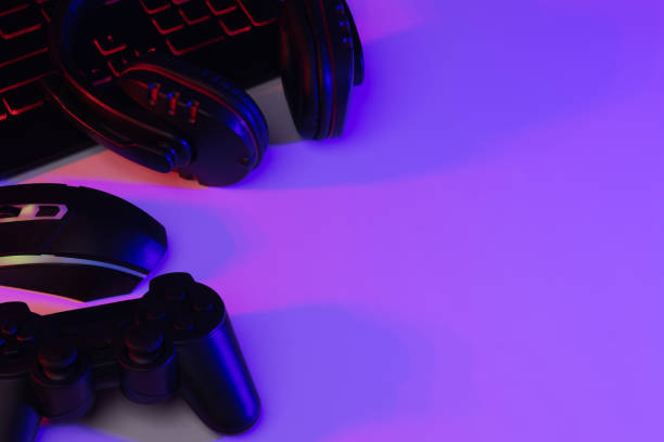 istock Accessory gaming keyboard joystick mouse headphone with blank space. Gadget for gamer playing video game online in the neon light darkroom. 1350960526