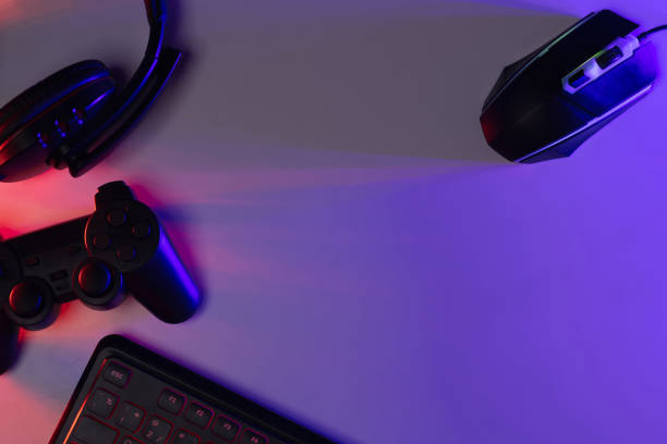 istock Accessory gaming keyboard joystick mouse headphone with blank space. Gadget for gamer playing video game online in the neon light darkroom. 1350960533