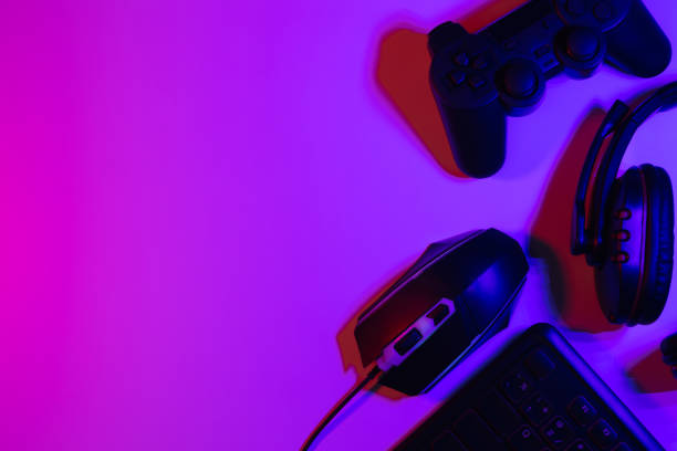 istock Accessory gaming keyboard joystick mouse headphone with blank space. Gadget for gamer playing video game online in the neon light darkroom. 1350960541