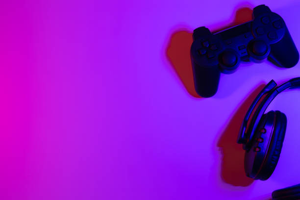 istock Accessory gaming keyboard joystick mouse headphone with blank space. Gadget for gamer playing video game online in the neon light darkroom. 1350960542