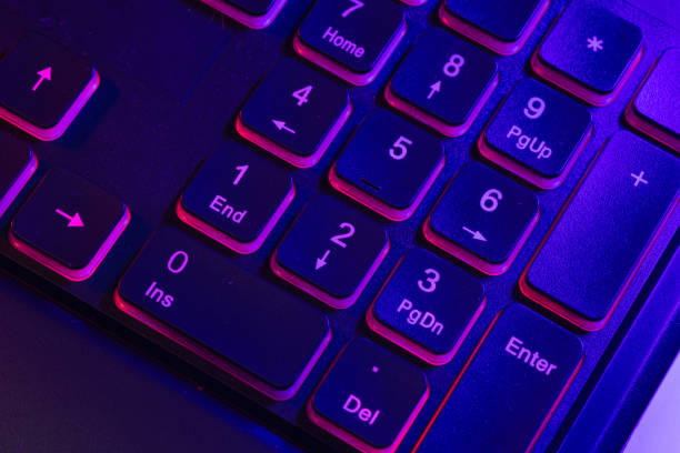 istock Accessory gaming keyboard with blank space background. Gadget for gamer playing video game online in the neon light darkroom. 1350960545