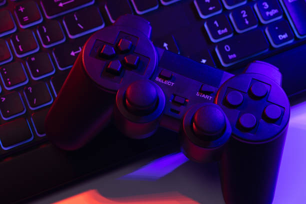 istock Accessory gaming keyboard joystick mouse headphone with blank space. Gadget for gamer playing video game online in the neon light darkroom. 1350960548