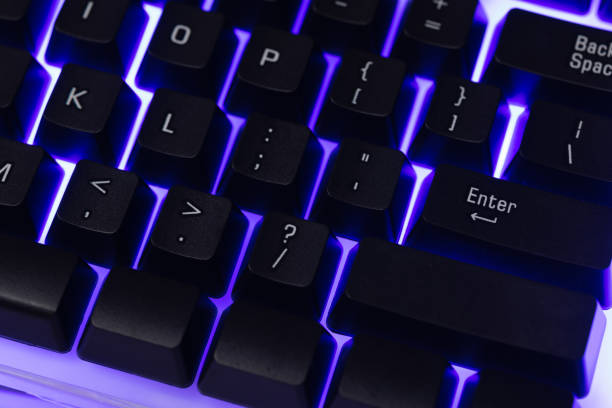 istock Colorful Accessory gaming keyboard with blank space background. Gadget for gamer playing video game online in the neon light darkroom. 1350960556