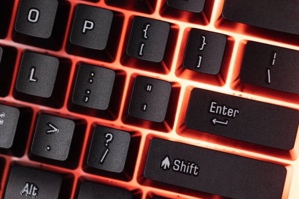 istock Colorful Accessory gaming keyboard with blank space background. Gadget for gamer playing video game online in the neon light darkroom. 1350960564