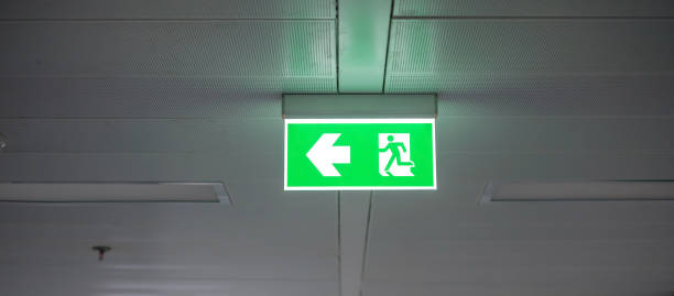 istock Fire Emergency exit sign on the wall inside building at subway train station. Safety concept 1350960764