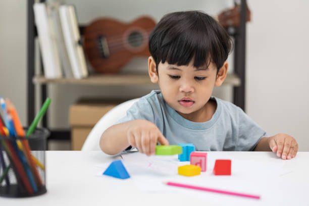 istock Asian little boy education from home. Developing children's learning before entering kindergarten Practice the skills of playing with wooden toys in living room. 1350961786
