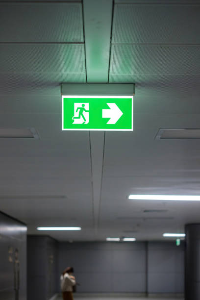 istock Fire Emergency exit sign on the wall inside building at subway train station. Safety concept 1350961823