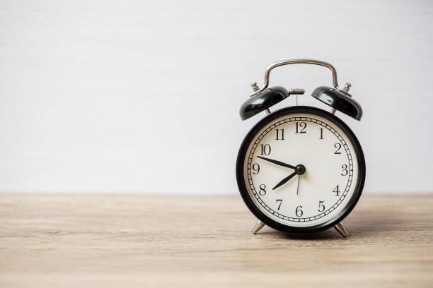 istock Vintage alarm clock on wooden table and copy space for text. Activity, daily routine, morning, workout and Work life balance concept 1350962921