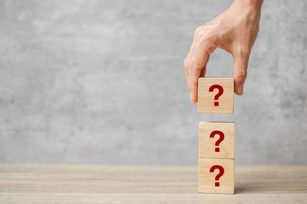 istock hand holding Questions Mark ( ? ) on cube block on table. FAQ( frequency asked questions), Answer, Q and A, Information, Communication and interrogation Concepts 1350962956