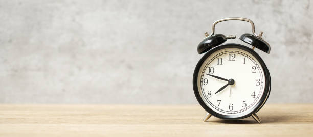 istock Vintage alarm clock on wooden table and copy space for text. Activity, daily routine, morning, workout and Work life balance concept 1350963055