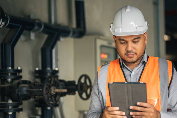 istock Young asian engineer working at electric cabinet checking and maintenance for the safety. Worker using tablet to control the system electric of the building. 1350963149
