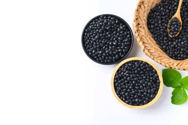 istock Black soy bean seeds in a bowl and basket with spoon on white background 1350973957