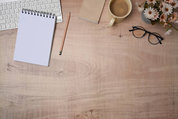 istock Top view empty notebook, coffee cup and glasses on wooden table. 1350975416