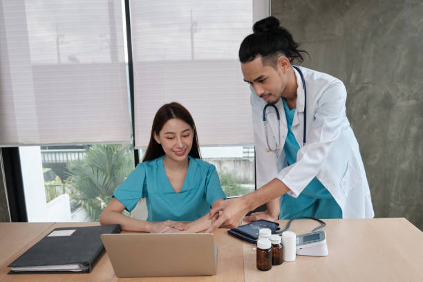 istock Two uniformed young doctors work in medical clinic office. 1350976781