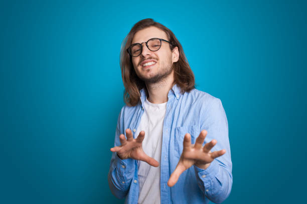 istock Modern man with beard gesturing hands on blue background. Greeting concept. Success concept. Handsome man. 1350982653