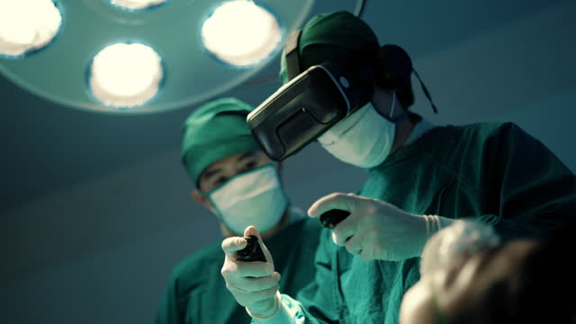 Asian surgeons using augmented reality glasses learning to examining human internal organ to perform surgery in modern hospital.