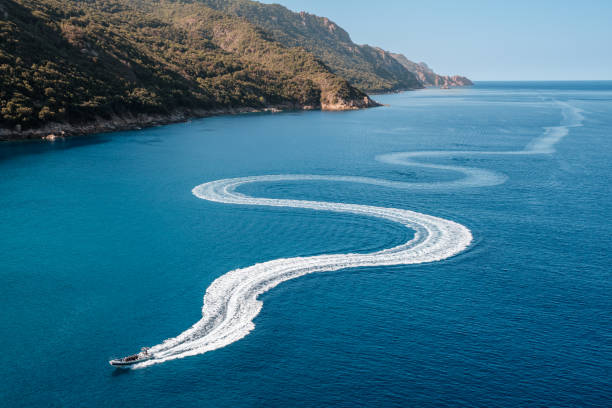 Pleasure boat snakes towards Porto in Corsica stock photo