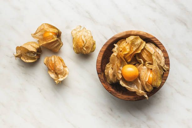 Physalis peruviana. Cape Gooseberry or ground cherries fruit. Physalis peruviana. Cape Gooseberry or ground cherries fruit on kitchen table. Top view. gooseberry cape winter cherry berry fruit stock pictures, royalty-free photos & images