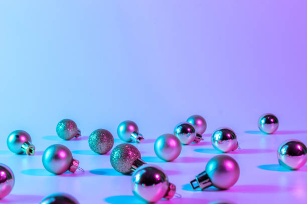istock Christmas balls pattern neon background. Xmas bauble on abstract holiday winter gradient backdrop. Happy new year copy space. 1350996941