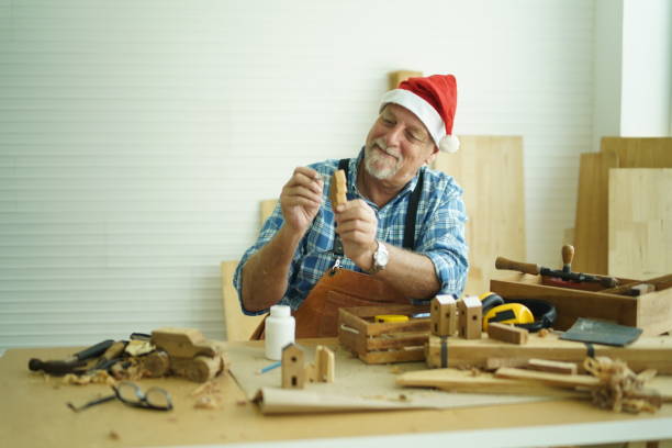 Senior carpenter wearing santa hat.